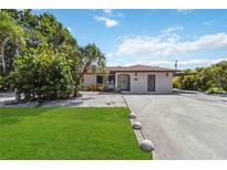 Charming single-story home with a well-manicured lawn and inviting curb appeal, complemented by lush tropical landscaping at 2555 Yucca Rd, Venice, FL 34293