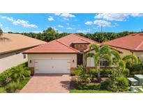 Charming single-story home featuring a red tile roof, well-manicured landscaping, and an attached two-car garage at 260 Soliera St, Nokomis, FL 34275