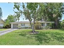 Inviting single-story home with a well-manicured lawn and mature trees creating a serene and picturesque setting at 3340 Webber St, Sarasota, FL 34239