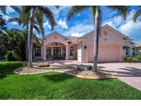 Inviting home featuring lush landscaping, mature palms, and a charming front patio at 4308 Via Del Santi, Venice, FL 34293