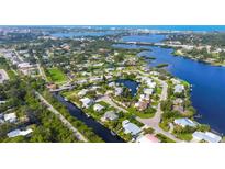 Stunning aerial view of waterfront homes and canals in a lush, tropical community with beautiful blue waterways at 458 Ceil Ct, Nokomis, FL 34275