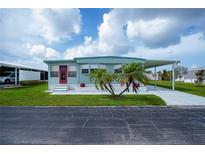 Charming single-story home with a well-maintained lawn, carport, and red front door at 527 Walnut Cir, Venice, FL 34285