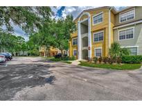 Attractive yellow condominium building with well-maintained landscaping and ample parking at 5459 Bentgrass Dr # 2-304, Sarasota, FL 34235