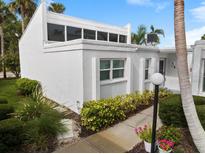 Charming home with modern architectural details, manicured landscaping, and a well-lit walkway to the entrance at 751 Capri Isles Blvd # 108, Venice, FL 34292