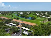 Beautiful aerial view of a condo complex with a golf course and pond in the background at 849 Wexford Blvd # 849, Venice, FL 34293