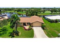 Charming single-story home with well-manicured lawn, landscaping, and water views at 925 S Doral Ln, Venice, FL 34293
