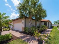Charming single-story home with lush landscaping, brick pathway, and attached two-car garage at 9917 Haze Dr, Venice, FL 34292