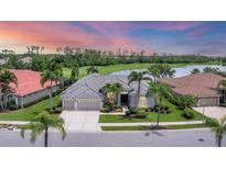 Beautiful single-story home with a well-manicured lawn and landscaping overlooking a large lake and golf course at 1210 Eagles Flight Way, North Port, FL 34287