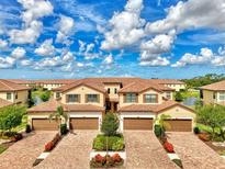 Beautiful, sunny aerial view of townhomes with brick driveways and manicured landscaping at 12590 Ghiberti Cir # 201, Venice, FL 34293