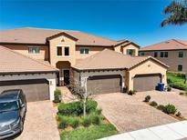 Stunning multi-story home featuring brick driveways, a tile roof and manicured landscaping under a clear blue sky at 23527 Awabuki # 202, Venice, FL 34293