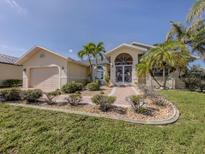Charming single Gathering home with a manicured lawn and front garden, along with a two car garage at 24339 Matias Ln, Punta Gorda, FL 33955