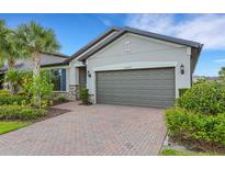 Beautifully landscaped one-story home with a brick paver driveway and a two-car garage at 2487 Marton Oak Blvd, North Port, FL 34289