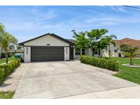 Charming single-story home featuring a well-maintained lawn, a two-car garage, and neatly trimmed landscaping at 26115 Rampart Blvd, Punta Gorda, FL 33983