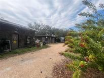 A unique stone exterior with a gravel driveway and mature landscaping at 3016 17Th St., Sarasota, FL 34234