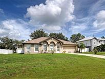 Charming single-story home featuring a well-manicured lawn and an attached two-car garage at 3139 Point St, North Port, FL 34286