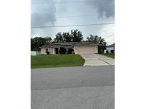 Charming single-story home featuring a two-car garage and solar panels for energy efficiency at 3601 Point St, North Port, FL 34286
