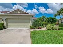 Charming home featuring an attached garage and lush tropical landscaping at 371 Capulet Dr, Venice, FL 34292
