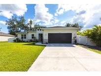 Charming single-story home showcasing a well-manicured lawn, spacious driveway and a two car garage at 4033 Union Ln, North Port, FL 34288