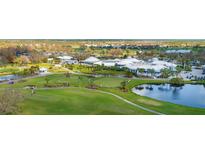 An aerial view of the golf course and clubhouse featuring manicured lawns and lush landscaping at 408 Cerromar S Cir # 331, Venice, FL 34293