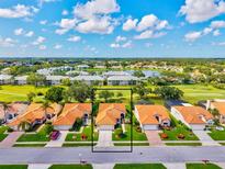 An aerial view of a single-Gathering home with a red tile roof and lush landscaping in a golf community at 4114 Murfield E Dr, Bradenton, FL 34203