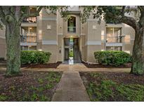 Condo exterior with beige siding, black balconies, and lush greenery at 5134 Northridge Rd # 303, Sarasota, FL 34238