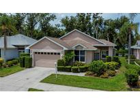 Charming single-story home boasts lush landscaping, a two-car garage, and a neatly maintained front yard at 519 Catalina Isles Cir, Venice, FL 34292