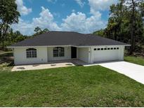 A charming one-story home with a well-maintained lawn, a two-car garage, and a concrete driveway at 5306 Maccaughey Dr, North Port, FL 34287