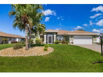 Charming single-story home featuring a well-manicured lawn and a picturesque palm tree in a beautifully landscaped front yard at 5818 Harrison Rd, Venice, FL 34293