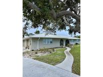 Charming single-story home featuring a well-manicured lawn, a winding walkway, and an attached two-car garage at 612 Bayshore Rd, Nokomis, FL 34275