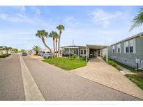 Charming home exterior featuring a covered carport and well-maintained landscaping with palm trees at 614 N Waterway, Venice, FL 34285