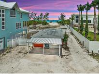 Coastal home showcasing a carport and beach access with stunning sunset hues at 616 S Casey Key Rd, Nokomis, FL 34275