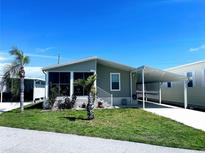 Inviting single-story home featuring a screened porch and covered parking, complemented by mature landscaping at 623 Leisure, Venice, FL 34285