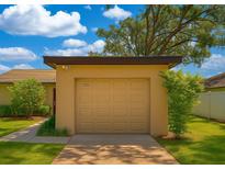 Attached one car garage with a brown door and house number under an extended roof at 7201 Daiquiri Ln, Tampa, FL 33634