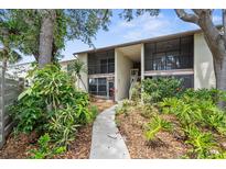 Condo exterior featuring well-maintained landscaping and mature trees, and screened in patios and balconies at 756 White Pine Tree Rd # 204, Venice, FL 34285
