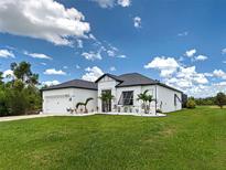 Charming single-story home featuring a well-manicured lawn and white rock landscaping for added curb appeal at 9157 Genesee St, Port Charlotte, FL 33981