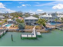 Stunning waterfront home featuring private dock, lush landscaping, and multiple balconies with beautiful turquoise water views at 931 Inlet Cir, Venice, FL 34285