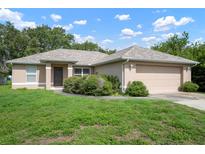 Welcoming single-story home with lush greenery and an attached two-car garage exudes charm and curb appeal at 2397 Morton Rd, North Port, FL 34291