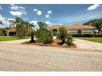 A single-story home with desert-style landscaping and a red tile roof under a blue sky with white clouds at 1136 Deardon Dr, Venice, FL 34292