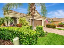 Inviting home featuring a brick driveway, lush landscaping, and a two-car garage at 11739 Okaloosa Dr, Venice, FL 34293