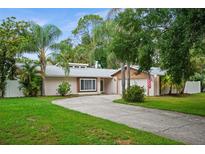 Charming single Gathering home with lush landscaping, palm trees, and a quaint front entrance at 13608 Westshire Dr, Tampa, FL 33618