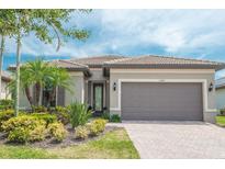 Charming single Gathering home showcasing a paved driveway and lush, well-maintained landscaping at 13871 Miranese St, Venice, FL 34293