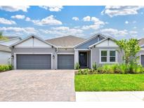 Charming single-story home featuring a three-car garage, lush landscaping, and a welcoming entrance at 1607 Laurel Brook Ln, Port Charlotte, FL 33953