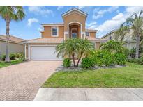 Inviting two-story home featuring a well-manicured lawn and a spacious two-car garage at 2146 Snapdragon Ln, Venice, FL 34292
