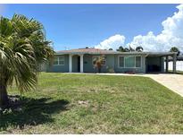Charming single-story home featuring a well-maintained lawn, carport and mature palm trees at 232 Fiesole St, Venice, FL 34285