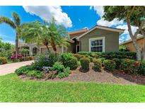Charming home featuring lush landscaping, including palm trees, colorful flowers, and manicured shrubs at 2944 Oriole Dr, Sarasota, FL 34243