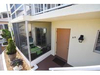 Inviting condo entrance with screen enclosed porch, neutral paint, and unit 215 address at 320 Base E Ave # 215, Venice, FL 34285