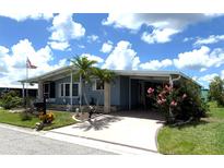 Charming single-story home featuring a covered carport, well-maintained lawn, and beautiful landscaping at 344 Mariner Dr, North Port, FL 34287