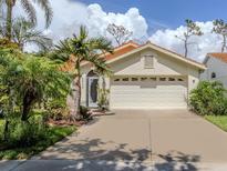 Charming single-story home with a well-manicured lawn, mature landscaping, and a two-car garage at 4176 Summertree Rd, Venice, FL 34293