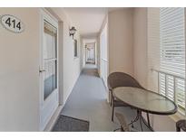 Long hallway with patio and exterior furniture near unit 414 at 437 Cerromar Ln # 414, Venice, FL 34293