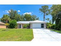Charming single-story home features a well-manicured lawn and a spacious driveway leading to an attached two-car garage at 6964 Glacier Ave, North Port, FL 34291